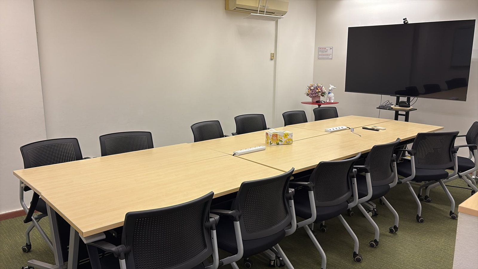 The face-to-face classroom on Beach Road, Singapore &mdash; a long table with chairs for a small hands-on class, and a large screen at the front.